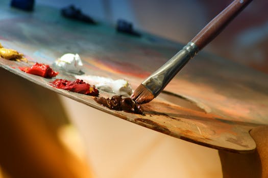 Artist painting in a studio with financial documents